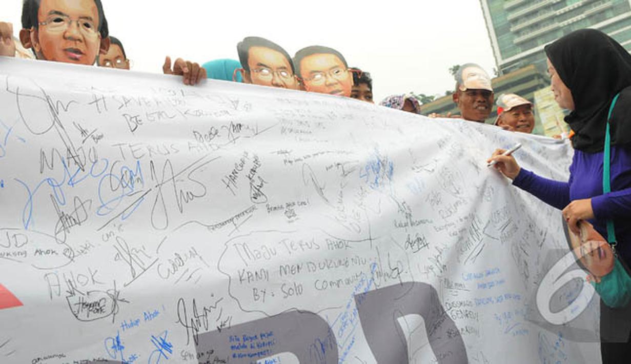 Seorang wanita membubuhkan tandatangannya saat aksi 'Lawan Begal APBD' di Bundaran HI, Jakarta, Minggu (1/3/2015). Aksi mereka sebagai bentuk dukungan kepada Ahok yang ingin membongkar dana siluman di Pemprov DKI (Liputan6.com/Herman Zakharia)