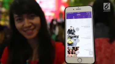 Pengunjung menunjukan aplikasi ovo untuk transaksi belanja di Plaza Semanggi, Jakarta, Jumat (8/12). Aplikasi tersebut memberikan program tarif parkir Rp1 dan cashback 30% di tenant F&B dan fashion Seluruh Lippo Mall Indonesia. (Liputan6.com/Angga Yuniar)