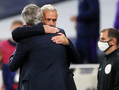 Pelatih Tottenham Hotspur, Jose Mourinho, berpelukan dengan pelatih Everton, Carlo Ancelotti, pada laga Premier League, Senin (6/7/2020). Mourinho melanggar aturan jarak sosial demi memeluk Carlo Ancelotti yang merupakan idolanya. (AFP/Adam Davy)