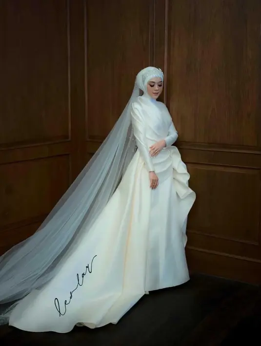 Gaun nuansa ultra-modern dengan aksen drapery di bagian pinggang menemani Lesti Kejora di hari pernikahannya. [Instagram/lestykejora]