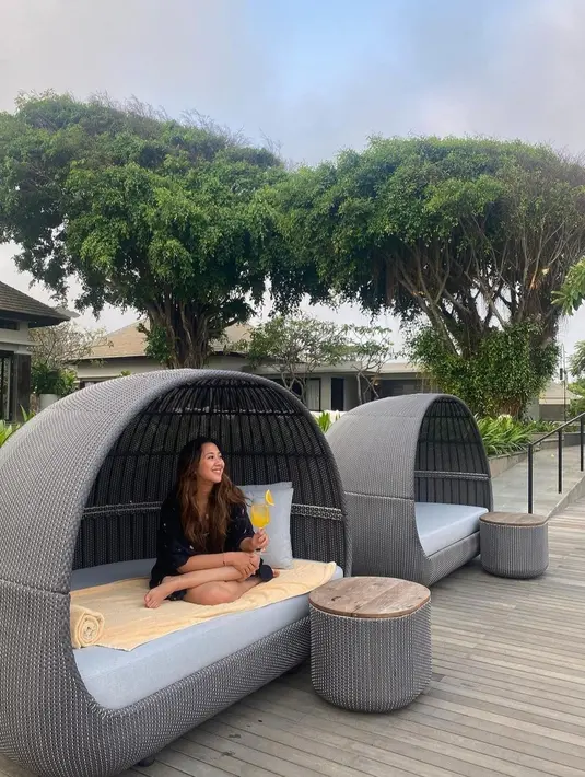 Duduk sambil minjum jus juga dilakukan Sherina saat di Bali. Dia terlihat santai dengan mini dress hitam.