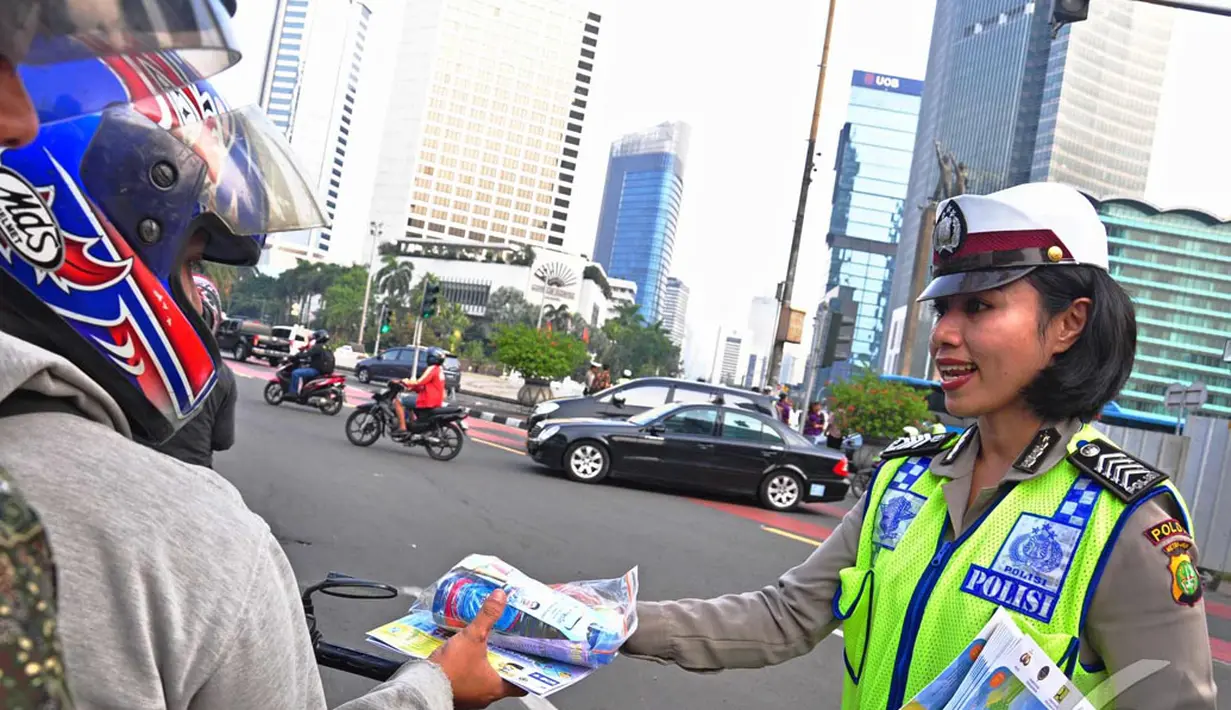 Petugas Kepolisian Direktorat Lalu Lintas Polda Metro Jaya bagikan peta mudik gratis, Jakarta, Jumat (18/07/2014)(Liputan6.com/Faizal Fanani)