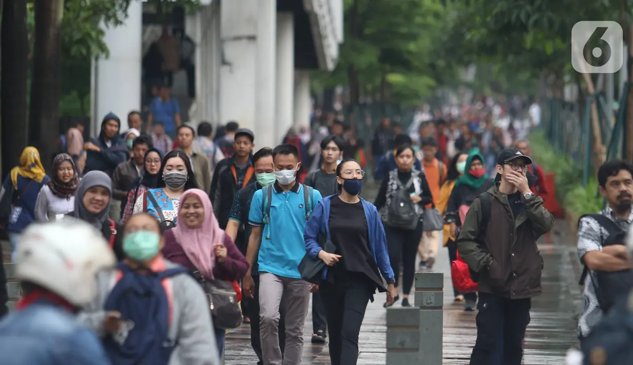Pekerja berjalan kaki saat jam pulang di kawasan Sudirman, Jakarta, Jumat (7/2/2020). BPJS Ketenagakerjaan yang kini bernama BP Jamsostek menargetkan sekitar 23,5 juta tenaga kerja baru masuk dalam daftar kepesertaan pada 2020. (Liputan6.com/Angga Yuniar)