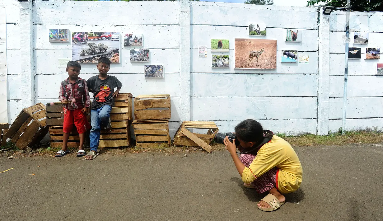Anak-anak belajar memotret dengan kamera DSLR saat kegiatan pameran Lensa Anak Terminal di Sekolah Master, Depok, Jawa Barat, Rabu  (8/2/2023). Pameran 170 karya foto dari 12 anak-anak terminal di kawasan tersebut merupakan hasil pembelajaran bersama Komunitas Lensa Anak Terminal dan berlangsung  hingga 12 Februari 2023. (merdeka.com/Arie Basuki)