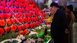 Orang-orang mengunjungi pameran bunga 'Kimjongilia' di Pyongyang, Kamis (14/2). Korea Utara menggelar festival bunga untuk merayakan ulang tahun mendiang mantan pemimpin tertinggi Korea Utara yang juga ayah Kim Jong-un, Kim Jong-il. (AP/Jon Chol Jin)