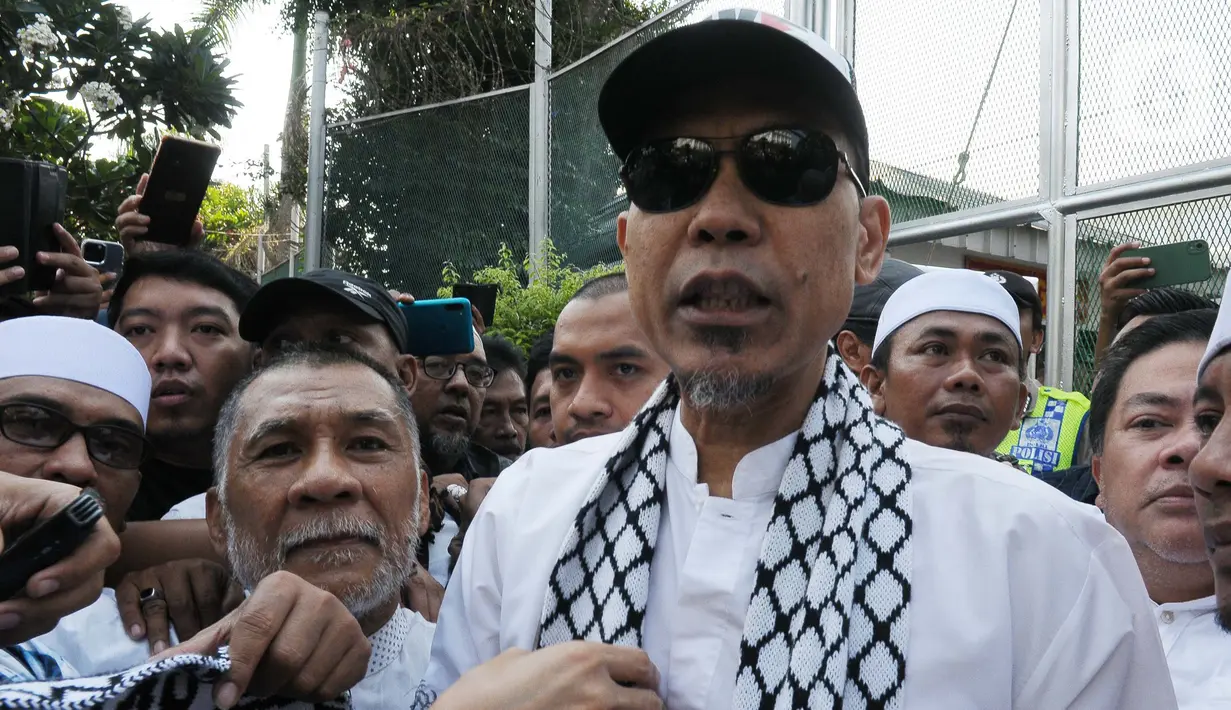 Munarman tampak keluar dari Lapas Salemba mengenakan sorban dan topi dengan tulisan 'Save Palestine'. (merdeka.com/Imam Buhori)