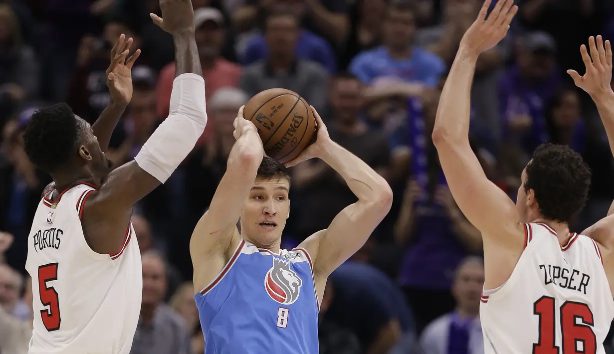 Aksi pemain Sacramento Kings, Bogdan Bogdanovic (tengah) mencoba memberikan umpan saat diadang dua pemain Chicago Bulls pada lanjutan NBA basketball game di Golden 1 Center, Sacramento, (5/2/2018). Kings menang  104-98. (AP/Rich Pedroncelli)