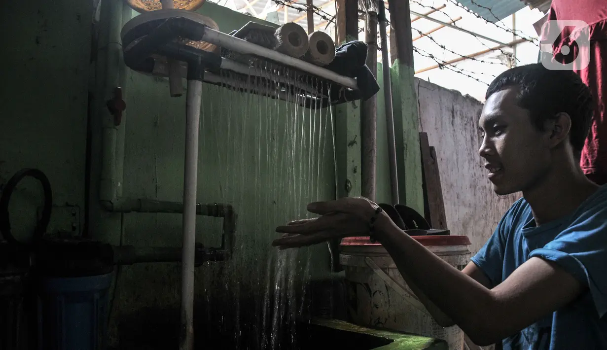 Warga menggunakan alat penyaring agar air menjadi bersih di Kampung Baru Kubur, Penjaringan, Jakarta Utara, Selasa (11/1/2022). Selain mengering, air di sebagian rumah berwarna keruh dan bau tak sedap. (merdeka.com/Iqbal S. Nugroho)