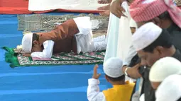 Bocah berbaju coklat ini asyik sujud sendiri ketika semua jamaah sedang berdiri. Kawannya yang berbaju kuning terlihat bingung, Hyderabad, India, Senin (6/10/2014) (AFP Photo/Noah SEELAM) 