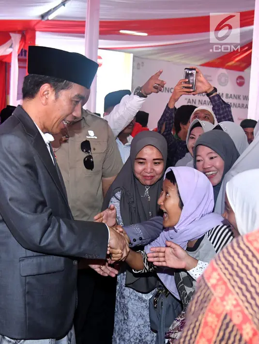 Presiden Joko Widodo atau Jokowi menyapa warga saat meresmikan Bank Wakaf Mikro di Serang, Banten, Rabu (14/3). Tiap kelompok nasabah Bank Wakaf Mikro terdiri dari tiga hingga lima orang. (Liputan6.com/Pool/Biro Setpres)
