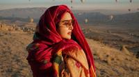 Gaya modis dan glamornya saat di Cappadocia pun diperlengkap dengan aksesori berupa  kacamata orange dan syal warna merah, makin chic! (Instagram/ashanty_ash).