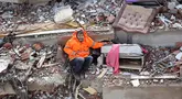 Mesut Hancer menggandeng tangan putrinya yang berusia 15 tahun, Irmak, yang tewas akibat gempa di Kahramanmaras, dekat pusat gempa, sehari setelah gempa berkekuatan 7,8 skala Richter mengguncang Turki tenggara, pada 7 Februari 2023. (Adem ALTAN / AFP)