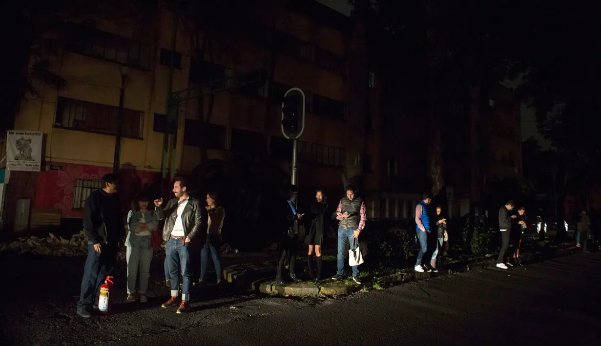 Sejumlah warga berkumpul di jalan saat terjadi gempa bumi di di lingkungan La Roma di Mexico City,(7/9). Akibat gempa tersebut Survei Geologi AS mengeluarkan peringatan tsunami. (AP Photo / Rebecca Blackwell)