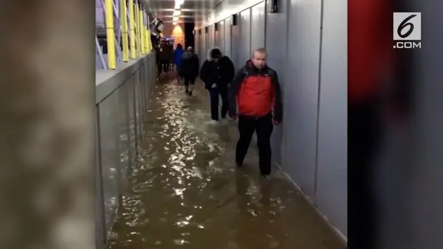 Akibat adanya badai Eleanor, warga kota London harus berjalan di tengah banjir.