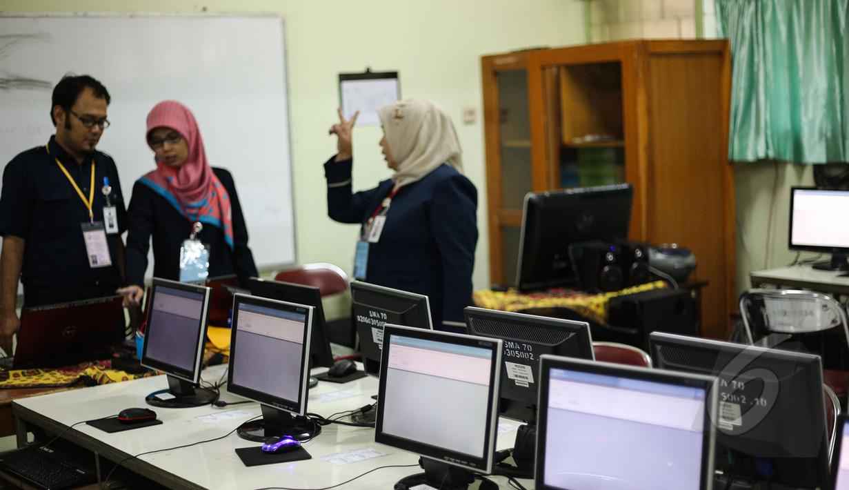 Sejumlah Guru mempersiapkan komputer untuk ujian nasional (UN) di SMA 70, Jakarta, Senin (13/4/2015). Sebanyak 585 dari 70 ribu sekolah menjadi percontohan menjalankan ujian nasional berbasis komputer di seluruh Indonesia.  (Liputan6.com/Faizal Fanani)