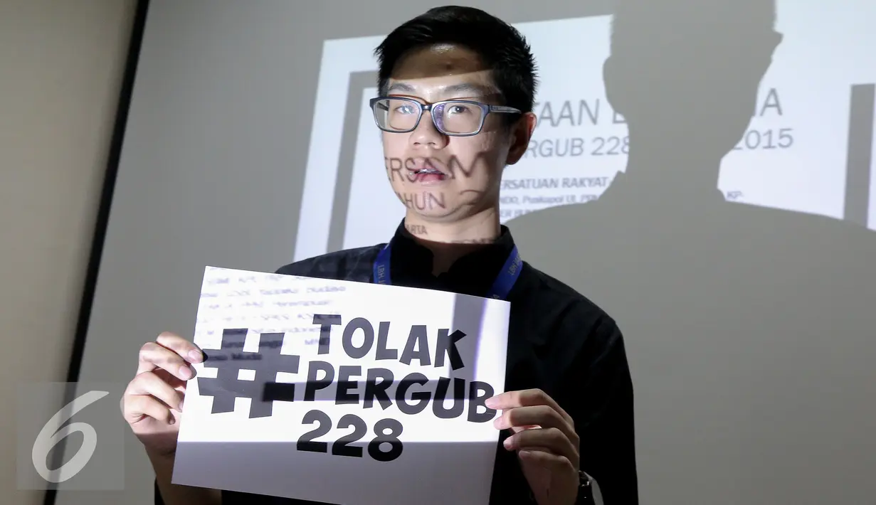 Aktivis  membentangkan spanduk bertuliskan "tolak Pergub 228" di kantor LBH Jakarta, Jum'at (11/6/2015). Mereka menolak keras peraturan gubenur Jakarta No 228 Tahun 2015 . (Liputan6.com/Faizal Fanani)