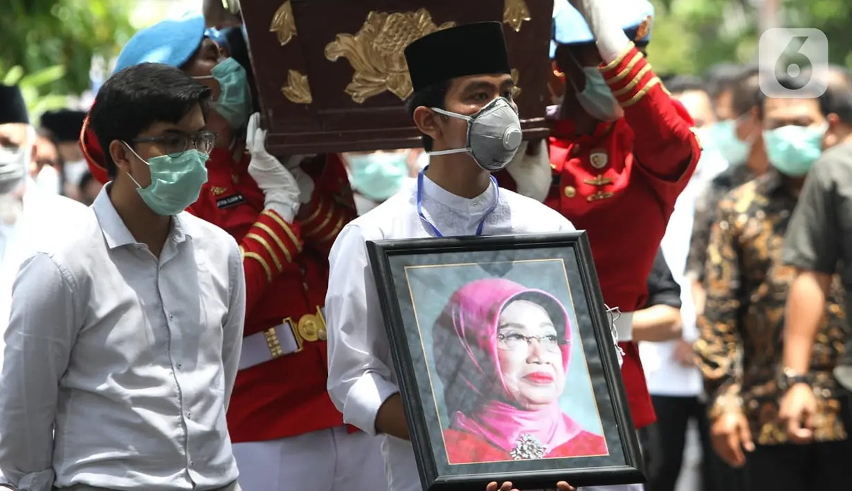 Putra Presiden Joko Widodo, Gibran Rakabuming Raka (kanan) serta adiknya Kaesang Pangarep membawa foto sang nenek Sudjiatmi Notomihardjo saat akan disalatkan di masjid dekat kediamannya di Solo, Jawa Tengah, Kamis (26/3/2020). Ibunda Jokowi meninggal karena sakit kanker. (Liputan6.com/Fajar Abrori)
