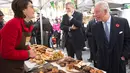 Pangeran Charles berbincang dengan pedagang ketika mengunjungi Swiss Cottage Farmers Market di London utara, Rabu (6/11/2019). Kunjungan Pangeran Charles dan Camila untuk mengucapkan selamat dan memperingati ulang tahun ke-20 pasar tersebut. (Eddie Mulholland / POOL / AFP)