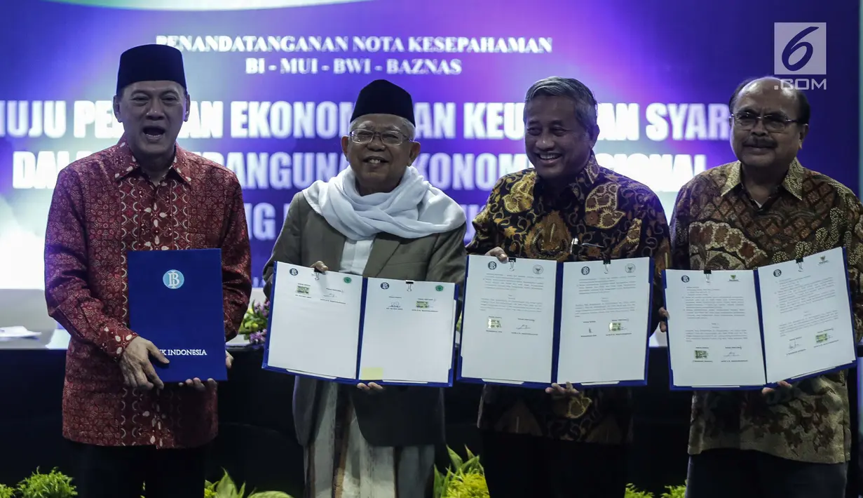 Gubernur BI Agus Martowardoyo, Ketua Umum MUI Ma'ruf Amin, Ketua Badan Wakaf Indonesia (BWI) Mohammad Nuh, dan Ketua Baznas Bambang Sudibyo menunjukkan MoU di Gedung MUI, Jakarta, Rabu (24/1). (Liputan6.com/Faizal Fanani)