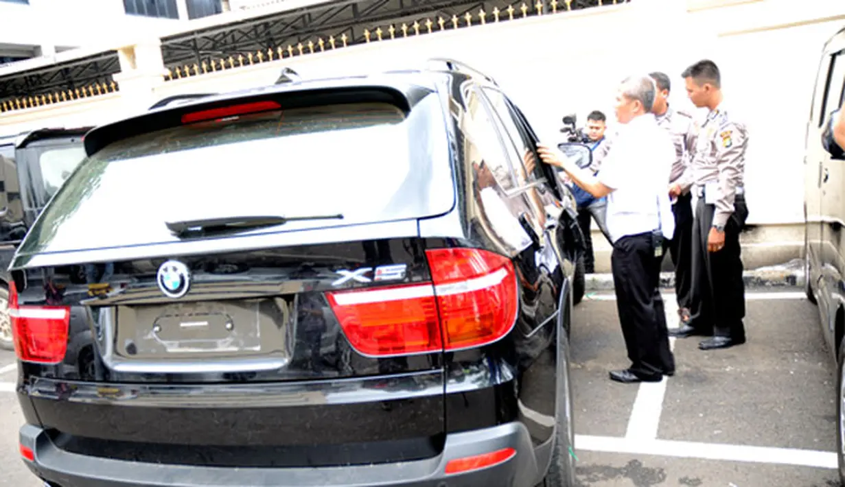 Polisi sedang menutup kaca BMW Rasyid Rajasa. Bagian belakang mobil masih mulus. (Liputan6.com/Helmi Fithriansyah)
