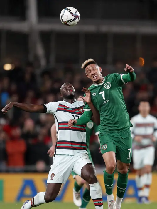 Bek timnas Irlandia, Callum Robinson berebut bola dengan gelandang Portugal Danilo Pereira pada laga Grup A Kualifikasi Piala Dunia 2022 Zona Eropa di Stadion Aviva, Jumat (12/11/2021) dinihari WIB. Diwarnai kartu merah Pepe, Portugal ditahan imbang 0-0 oleh Irlandia. (AP Photo/Peter Morrison)