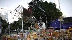 Mobil derek mengangkut barikade penutup lokasi utama berlangsungnya aksi demonstasi massa pro-demokrasi di Admiralty, Hong Kong, (13/10/2014). (REUTERS/Carlos Barria)