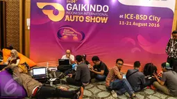  Sejumlah jurnalis sedang mengetik berita sambil duduk lesehan saat Gaikindo Indonesia International Auto Show (GIIAS) di pressroom ICE BSD, Tangerang Selatan (11/08). (Liputan6.com/Fery Pradolo)