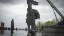 <p>Sebuah monumen era Soviet untuk persahabatan antara Rusia dan Ukraina terlihat selama pembongkarannya, di tengah invasi Moskow di Kiev tengah, Ukraina, Selasa (26/4/2022). Patung perunggu setinggi 8 meter itu menggambarkan seorang pekerja Ukraina dan Rusia di atas alas, memegang tinggi-tinggi tatanan persahabatan Soviet. (Genya SAVILOV / AFP)</p>