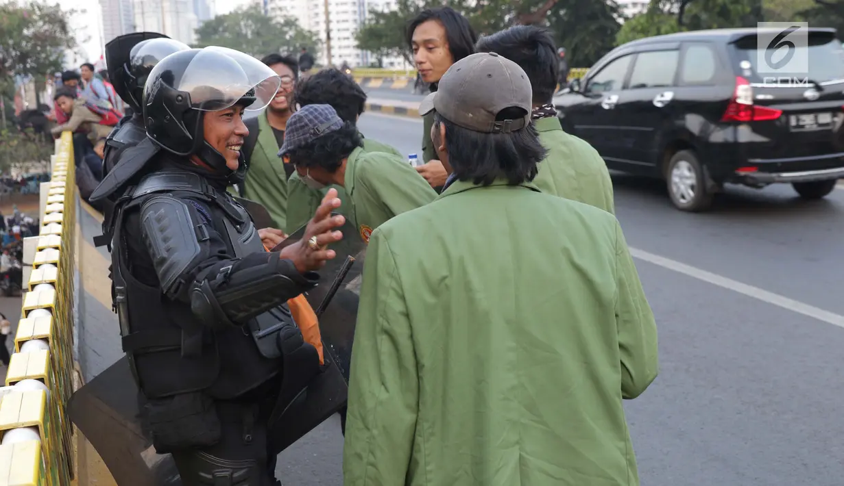 Mahasiswa dari salah satu perguruan tinggi bersalaman dengan personel Brimob usai melakukan aksi unjuk rasa di sekitar Jembatan Layang Gerbang Pemuda, Jakarta, Selasa (1/10/2019). Mahasiswa dari berbagai perguruan tinggi kembali berunjuk rasa menolak beberapa RUU. (Liputan6.com/Helmi Fithriansyah)