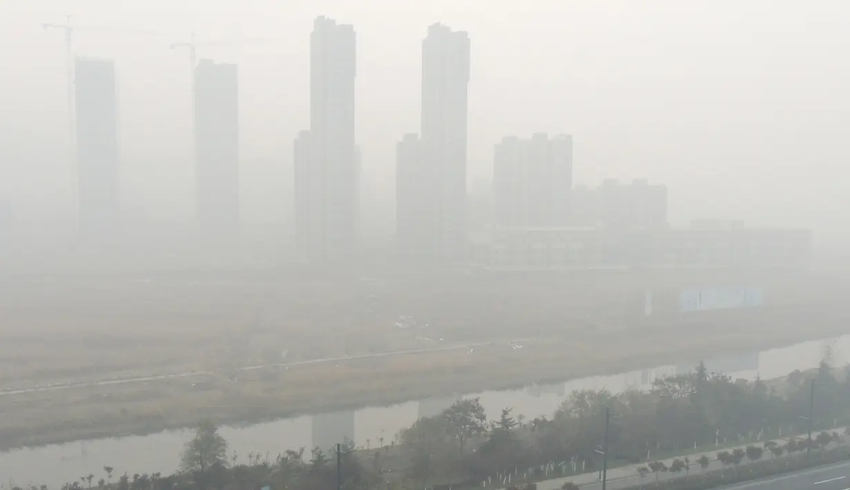 Gedung-gedung tertutup kabut asap yang melanda Beijing, China, Senin (30/11). Pemerintah setempat mengumumkan keadaan siaga dan menyarankan warga Beijing untuk tetap berada dalam rumah karena kandungan polusi udara yang berbahaya. (CHINA OUT AFP PHOTO)