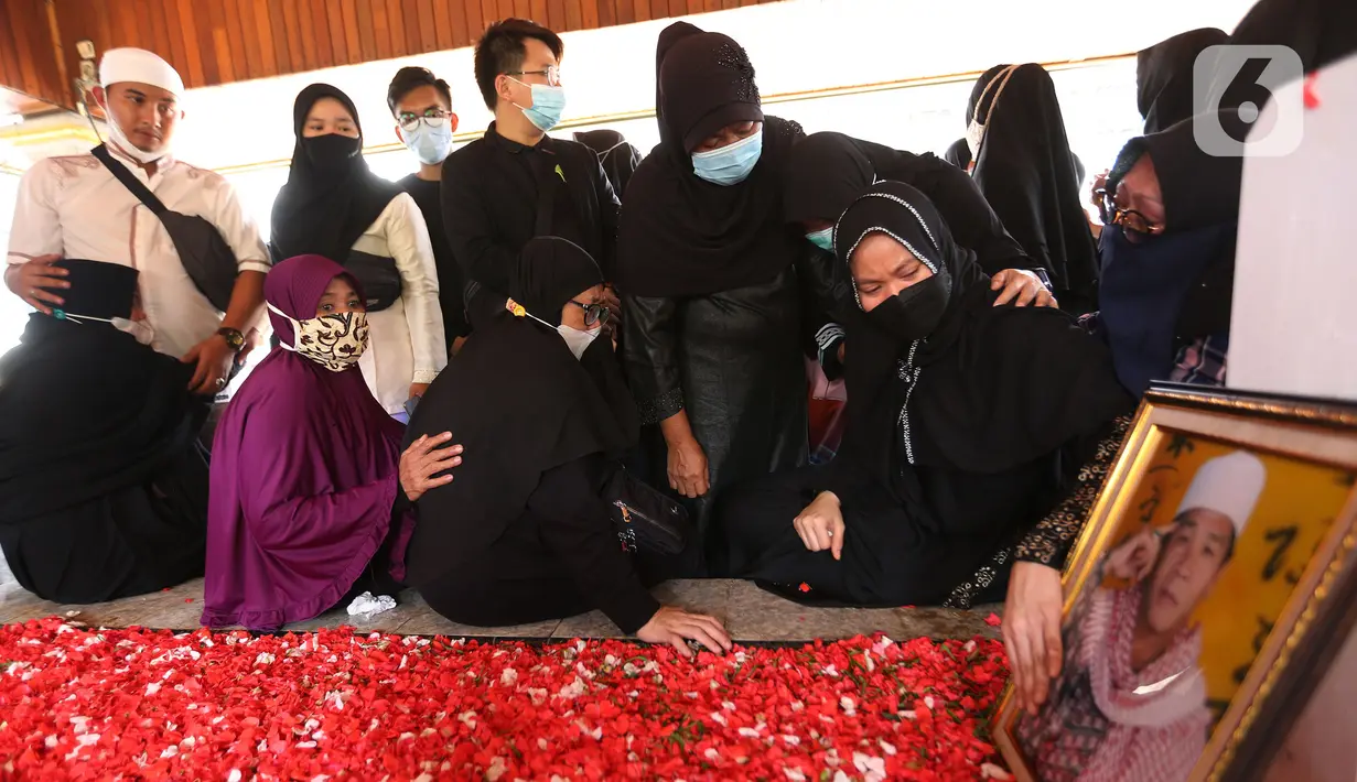 Sejumlah orang menangis di makam pendakwah Ramdhan Effendi atau Anton Medan saat pemakaman di area Masjid Tan Kok Liong, Pondok Rajeg, Cibinong, Bogor, Jawa Barat, Selasa (16/3/2021). Anton Medan dikenal kerap berdakwah dari lembaga pemasyarakatan (lapas) ke lapas. (Kapanlagi.com/Budy Santoso)