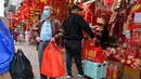 Orang-orang berbelanja dekorasi menjelang Tahun Baru Imlek di Hong Kong pada 26 Januari 2022. Tahun Baru Imlek untuk masyarakat Tionghoa atau China di seluruh dunia pada tahun ini akan jatuh pada tanggal 1 Februari 2022. (Peter PARKS / AFP)