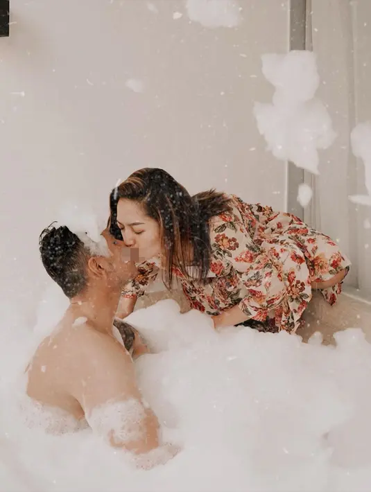 Di foto selanjutnya, pasangan yang menikah sebulan lalu itu pun berciuman. Siti Badriah yang memakai jubah mandi motif bunga ini mendekatkan bibirnya pada bibir Krisjiana. (Liputan6.com/IG/@sitibadriahh)