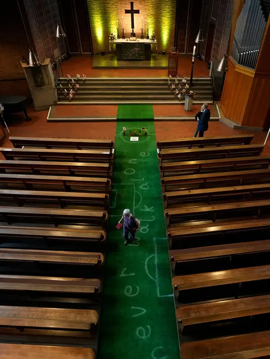 Karpet hijau bergambar lapangan sepak bola dipasang di koridor Gereja Evangelis Emaus di Gelsenkirchen, Jerman, Minggu, 23 Juni 2024. (AP Photo/Alessandra Tarantino)