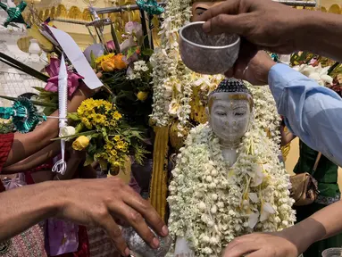 Para umat menuangkan air ke patung Buddha di Pagoda Shwedagon untuk menandai Hari Ulang Tahun Buddha, yang jatuh pada Hari Bulan Purnama Kasone, di Yangon pada 11 Mei 2025. (Sai Aung MAIN/AFP)