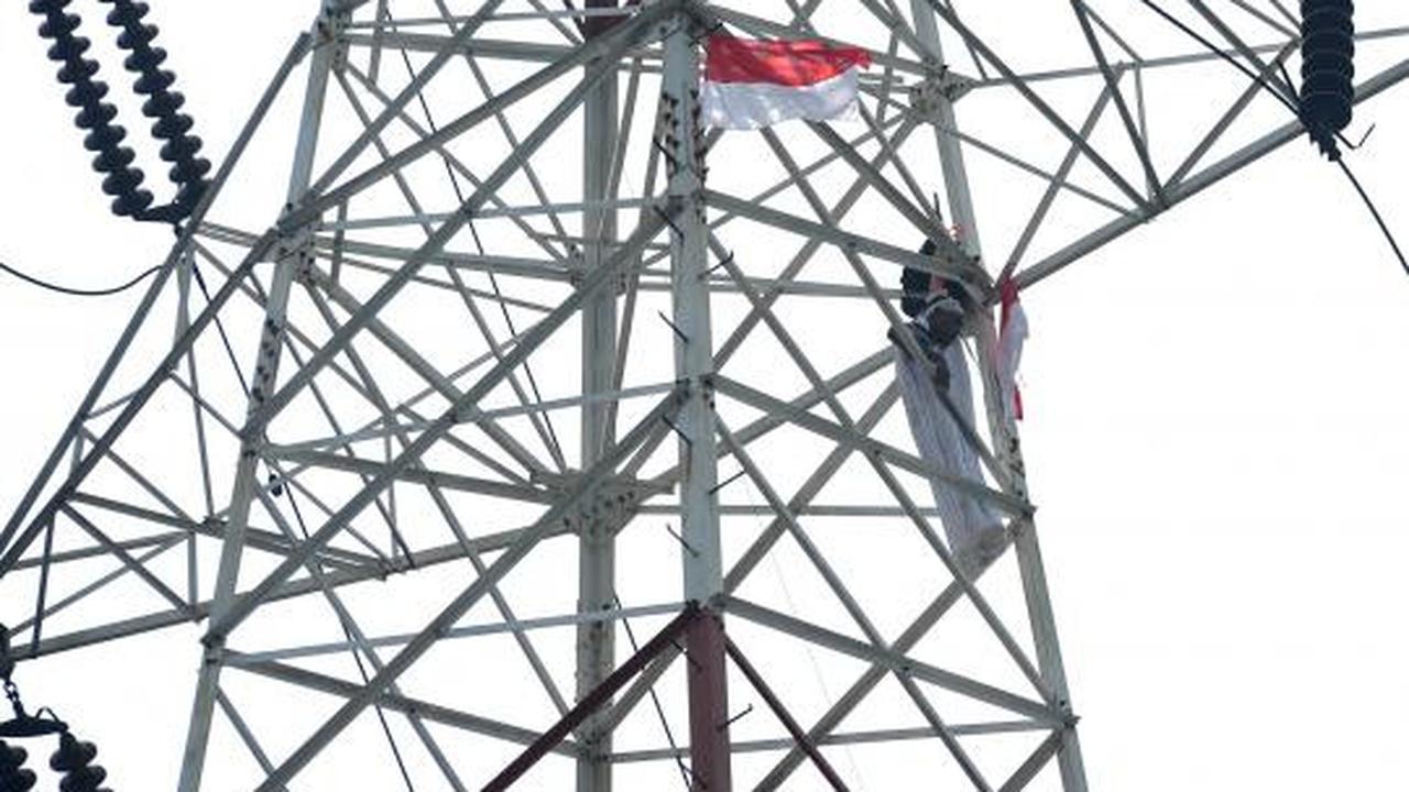Pria berpakaian pocong di atas tower SUTET