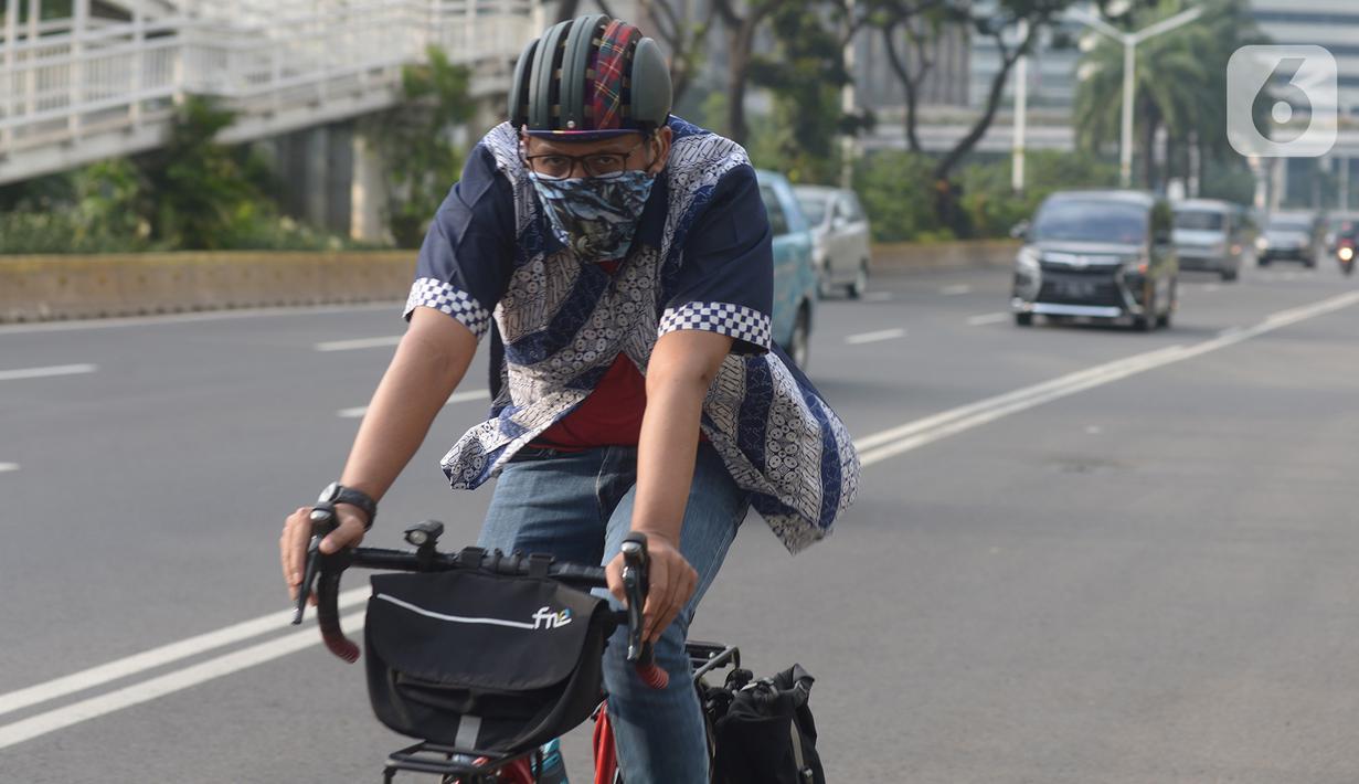 Seorang pria yang mengenakan baju batik bersepeda di kawasan Thamrin Sudirman, Jakarta, Jumat (2/10/2020). Pada Hari Batik Nasional yang berlangsung di tengah pandemi COVID-19, sebagian masyarakat terlihat mengenakan baju dan masker dengan motif batik. (merdeka.com/Imam Buhori)