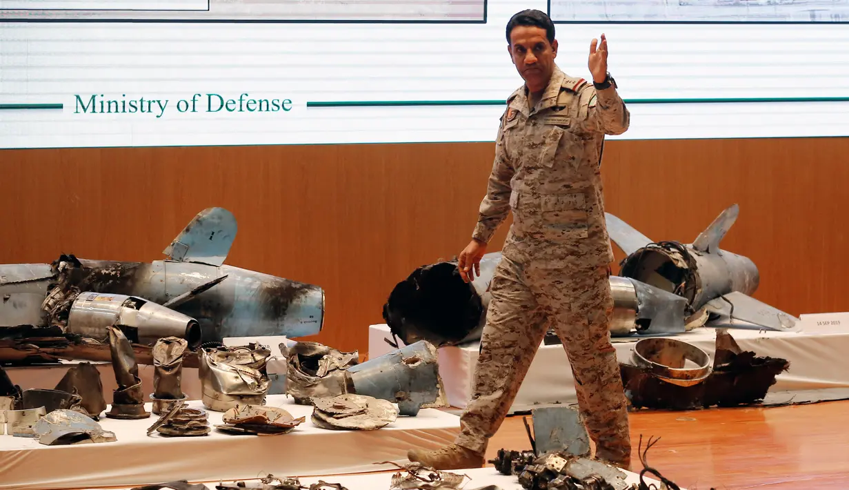 Perwira militer melewati puing-puing rudal yang digunakan dalam serangan kilang minyak Aramco pada konferensi pers di Riyadh, Arab Saudi, Rabu (18/9/2019). Jubir Kementerian Pertahanan Arab Saudi Kolonel Turki al-Malki menyebut serangan tidak diragukan lagi disponsori oleh Iran. (AP Photo/Amr Nabil)