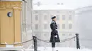 Seorang penjaga kerajaan berdiri saat salju turun di luar Royal Castle di Stockholm, Swedia (28/1/2021). Salju turun sekitar lima hingga sepuluh sentimeter diperkirakan akan turun - atau bahkan hingga 15 sentimeter di bagian pesisir di wilayah timur laut Uppsala. (Henrik Montgomery/TT via AP)