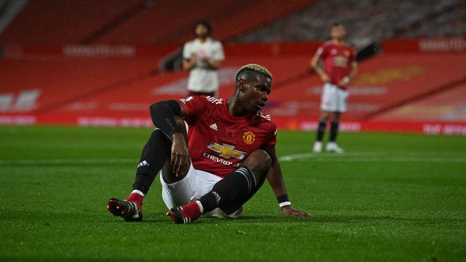 Gelandang Manchester United (MU) Paul Pogba terlihat lesu setelah melanggar bek Arsenal Hector Bellerin yang menghasilkan tendangan penalti pada pekan ketujuh Liga Inggris di Old Trafford. Minggu (1/11/2020). (Paul Ellis / Pool via AP )