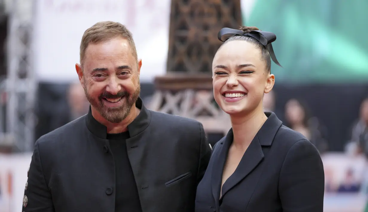 Rose Williams (kanan) bersama Sutradara Anthony Fabian tersenyum pada saat kedatangan untuk pemutaran perdana film 'Mrs. Harris Pergi ke Paris' di London (25/9/2022). (Photo by Scott Garfitt/Invision/AP)