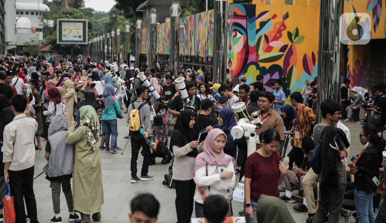Suasana saat para pengunjung mengamati gerhana matahari cincin di Planetarium Taman Ismail Marzuki, Jakarta, Kamis (26/12/2019). Planetarium menyediakan sekitar 10 teleskop dan kacamata khusus agar pengunjung bisa menyaksikan gerhana matahari cincin dengan aman. (Liputan6.com/Faizal Fanani)