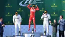 Pembalap Ferrari, Sebastian Vettel melompat merayakan kemenangannya di atas podium balapan GP Australia di Sirkuit Albert Park, Melbourne, Minggu (26/3). Ini merupakan kemenangan pertama Vettel bersama Ferrari sejak GP Singapura 2015. (WILLIAM WEST/AFP)