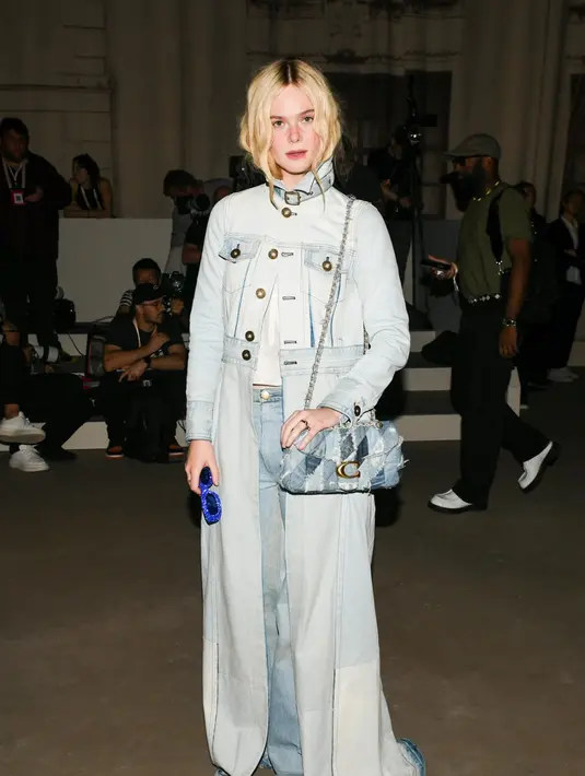 Elle Fanning tampil memukau dengan gaya denim on denim. Ia memadukan jaket denim longgar dengan celana panjang senada, menciptakan siluet kasual sekaligus chic. Look-nya semakin lengkap dengan tas Tabby berbahan denim yang mempertegas nuansa urban namun tetap elegan.