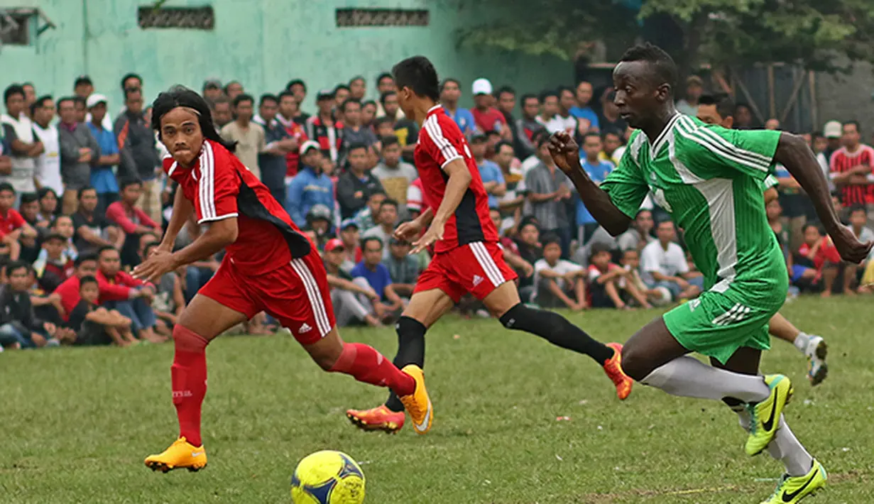 Aksi Makan Konate (hijau) pemain Persib yang turut  dalam liga tarkam di Ciputat ini. (Bola.com/Peksi Cahyo)