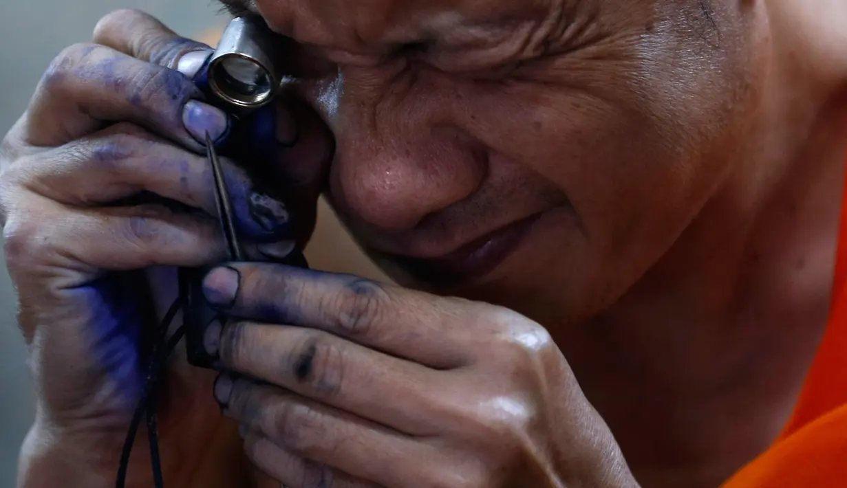 Seorang biksu Buddha mempersiapkan peralatan yang dipakai untuk menato di Wat Bang Phra, Nakhon Pathom, Thailand , (18/3). Tato yang mereka dapat di sini bukanlah tato biasa tetapi tato yang mempunyai kekuatan mistis. (REUTERS / Chaiwat Subprasom)