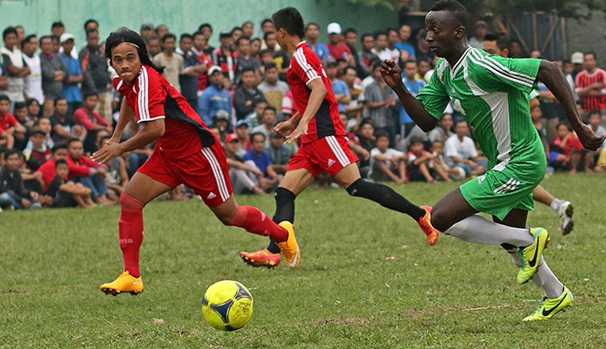 Aksi Makan Konate (hijau) pemain Persib yang turut  dalam liga tarkam di Ciputat ini. (Bola.com/Peksi Cahyo)