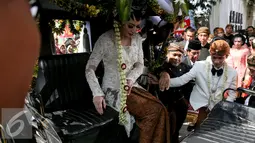 Pasangan pengantin Gibran-Selvi saat berada di kereta kuda usai resepsi pernikahannya dan akan menuju kediaman Gibran di Jalan Kutai Utara RT.08/RW.07 Sumber, Solo, Jateng, Kamis (11/6/2015). (Liputan6.com/Faizal Fanani)