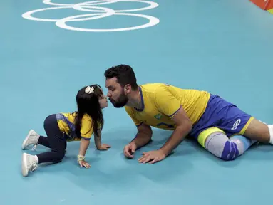 Pevoli Brasil, William, melakukan selebrasi unik dengan sang putri usai menaklukkan Rusia pada semifinal Olimpiade 2016 di Maracanazinho, Brasil, Sabtu (20/8/2016). Brasil menang 3-0 atas Rusia. (Reuters/Ricardo Moraes)