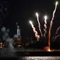 Kembang api yang diluncurkan dari tongkang meledak di atas Pelabuhan New York dan Patung Liberty di New York, Selasa (15/6/2021). Kembang api yang menandai berakhirnya pembatasan COVID-19 di seluruh negara bagian tersebut untuk menghormati para kelompok pekerja penting. (AP Photo/Craig Ruttle)